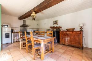 eine Küche mit einem Holztisch und Holzstühlen in der Unterkunft Aux 2 Puys - Gîte "Le Lemptégy" in Saint-Priest-des-Champs