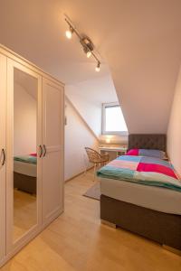 um quarto no sótão com uma cama e uma janela em Ferienwohnung Altötting em Unterneukirchen