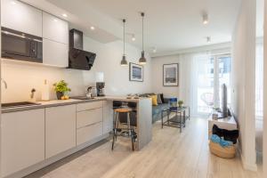 een keuken met witte kasten en een aanrechtblad bij Ambria Apartments Ułańska in Świnoujście