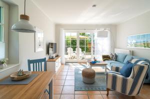 a living room with a blue couch and a table at Strandhaus Düne 19 - Freude in Neuhaus