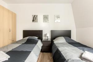 two beds sitting next to each other in a bedroom at Appartement style industriel, propre, WIFI Fibre in Roncq