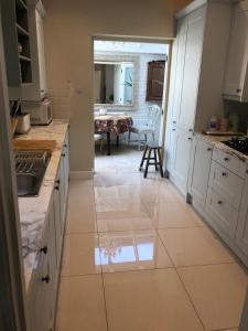 a kitchen with white cabinets and a tile floor at Victoria Villas in London +18 photos