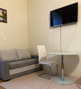 a living room with a couch and a table and a tv at Apartment 19 Vila Golf Nice Vacation in Rogaška Slatina