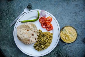 a white plate of food with food on a table at PushkarOrganic - Lux farm resort with pool in Pushkar