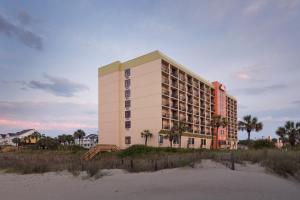 a hotel on the beach next to the beach at Surfside Beach Oceanfront Hotel in Myrtle Beach