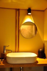 bagno con lavandino bianco e specchio di Tiny House Célestine By Ernesst a Overijse Altre 13 foto