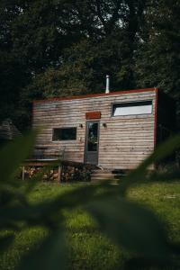 une petite cabine avec une porte dans l'herbe dans l'établissement Tiny House Célestine By Ernesst, à Overijse