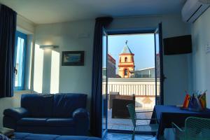 salon z kanapą i widokiem na wieżę zegarową w obiekcie Hotel Darsena w mieście Pozzuoli