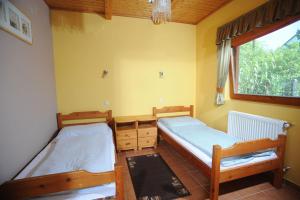 two beds in a room with a window at Wellness Park Pension in Gyenesdiás