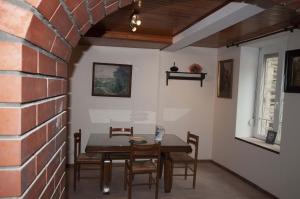 a dining room with a table and chairs and a brick wall at Le bateau ivre in Fumay