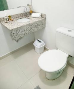 a white bathroom with a toilet and a sink at Pousada São Judas Tadeu in Cachoeira Paulista