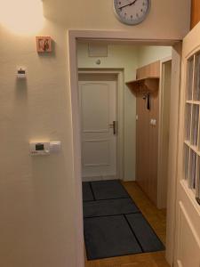 a hallway with a door and a clock on the wall at Apartment 19 Vila Golf Nice Vacation in Rogaška Slatina +4 photos