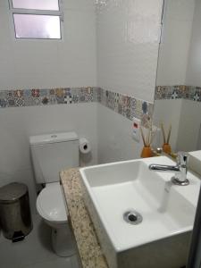 a bathroom with a white sink and a toilet at Pousada São Judas Tadeu in Cachoeira Paulista