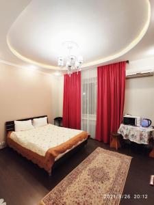 a bedroom with a bed and red curtains at Altyn in Astana
