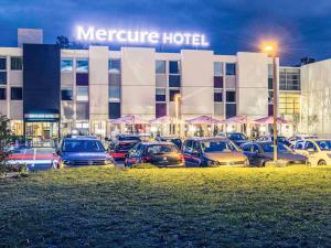a group of cars parked in a parking lot in front of a hotel at Mercure Le Mans Batignolles in Le Mans