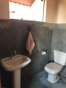 La salle de bains est pourvue d'un lavabo, de toilettes et d'une serviette. dans l'établissement Chácara Limp, à Abertão