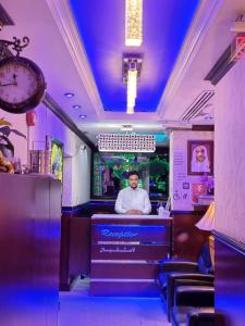 a man sitting at a bar in a restaurant at Karoon Hotel in Dubai