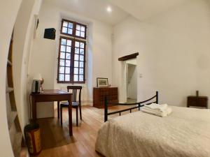 a bedroom with a bed and a desk and a window at Bauhaus Saint-Pierre in Gaillac