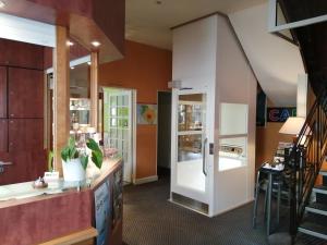 a room with a kitchen with a counter and a refrigerator at Logis Hôtel La Résidence in Cognac