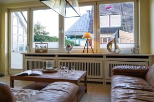 sala de estar con 2 sofás, mesa y ventanas en Meeresstern en Westerland