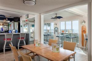 a dining room with a table and chairs and a bar at Surfside Beach Oceanfront Hotel in Myrtle Beach