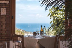 una mesa con copas de vino y vistas al océano en Hotel Castello Monticello en Giglio Porto