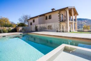 a house with a swimming pool in front of a house at EL SERRADELL AGROTURISME in Sant Joan de les Abadesses