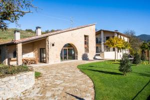 an external view of a house with a stone driveway at EL SERRADELL AGROTURISME in Sant Joan de les Abadesses