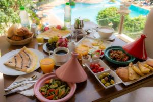 una mesa con comida para el desayuno y bebidas en ella en Hôtel Rembrandt, en Tánger