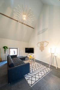 a living room with a couch and a tv at Le Grenier du Moulin in Héron