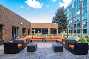 a courtyard with orange chairs and a building at Sheraton Ann Arbor Hotel in Ann Arbor