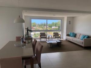 a living room with a table and a couch at Atlântida Green Square - 606B in Xangri-lá