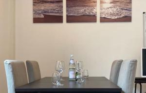 una mesa de comedor con sillas y botellas de vino. en Lux Apartment near Frankfurt!, en Mörfelden-Walldorf
