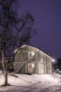 un bâtiment dans la neige la nuit dans l'établissement Frost Longstay Egnahemsvägen, à Kiruna