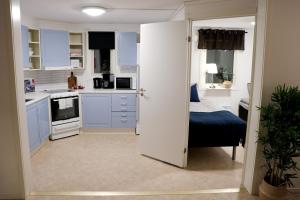 - une cuisine avec des placards bleus et un lit dans une chambre dans l'établissement Frost Longstay Egnahemsvägen, à Kiruna
