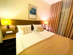 a hotel room with a large bed with white sheets and pillows at Hotel Hansehof in Hamburg