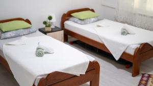 two beds in a room with white sheets at Kolev Apartments - Two Bedroom Cozy Central Apartment in Skopje