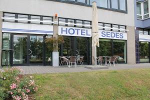 a hotel with tables and chairs in front of a building at Hotel Sedes in Berlin
