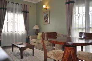 salon ze stołem i kanapą w obiekcie Home Bliss Hotel- Fort portal Uganda w mieście Fort Portal