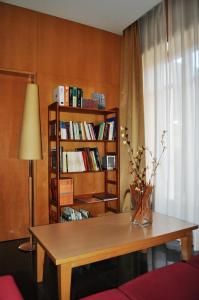 um quarto com uma mesa e uma estante de livros com livros em Hotel España em Guadalajara