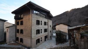 a large brick building with a balcony on top of it at La Meira Sermig Casa Ferie in Crissolo