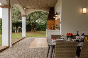 un patio al aire libre con mesa, sillas y un arco en Casa Fontanals, en Pla del Penedès