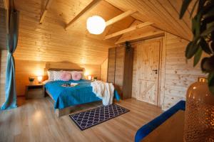 a bedroom with a bed in a wooden room at Z Bieszcza Rodem in Ustrzyki Dolne