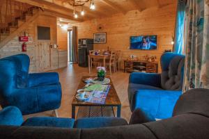 a living room with blue chairs and a table at Z Bieszcza Rodem in Ustrzyki Dolne