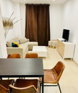 een woonkamer met een bank, een tafel en stoelen bij Be Suites Centro in Granada