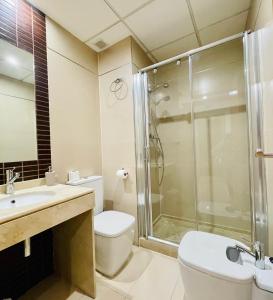 een badkamer met een douche, een toilet en een wastafel bij Be Suites Centro in Granada