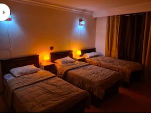 two beds in a hotel room with lights on them at Al Marwa Apartment in Dokki - Families Only in Cairo