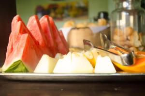 a plate with slices of fruit on a table at Pousada Solar do Algarve in Paraty +16 photos