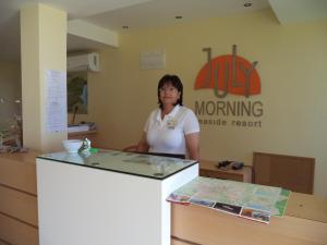 a woman standing behind a counter in a room at July Morning Seaside Resort in Kavarna