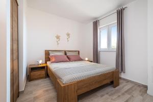 um quarto com uma cama e uma janela em House of Dalmatia em Pakoštane